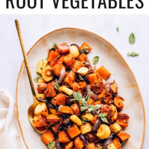 A serving platter with roasted root vegetables. A gold spoon rests in the platter.