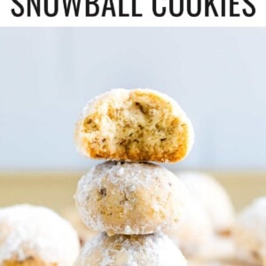 Stack of three snowball cookies. The top has a bite taken out of it.