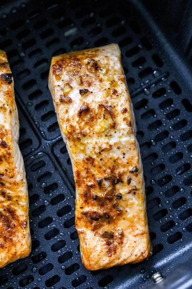 A closeup of air fryer salmon in an air fryer basket.
