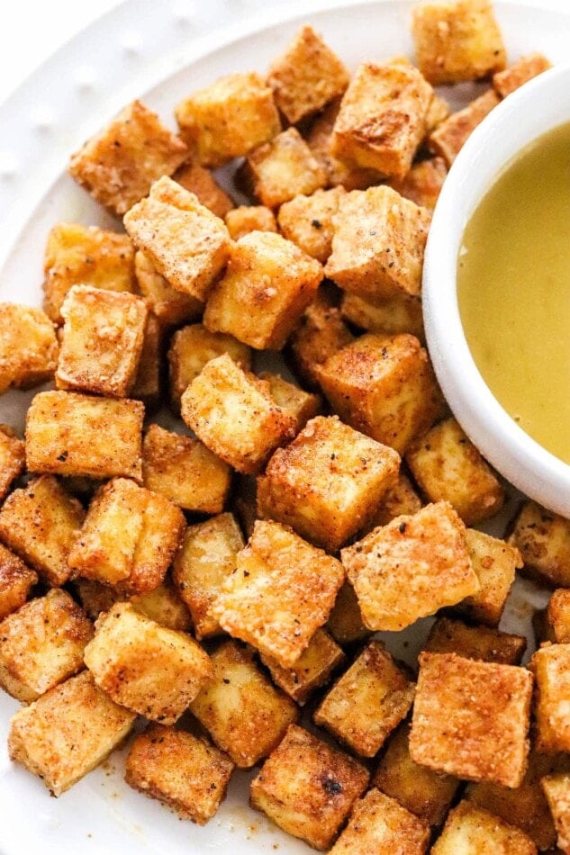 A close up photo of air fried tofu on a plate.