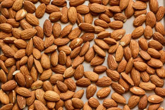 Almonds spread across a baking sheet.