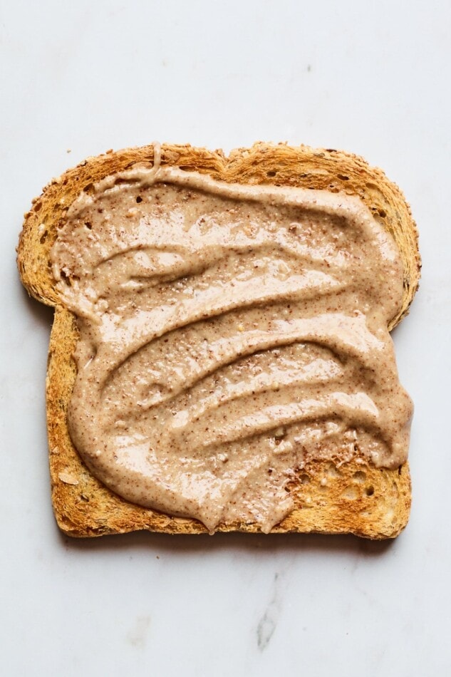 A slice of toast spread with creamy homemade almond butter.