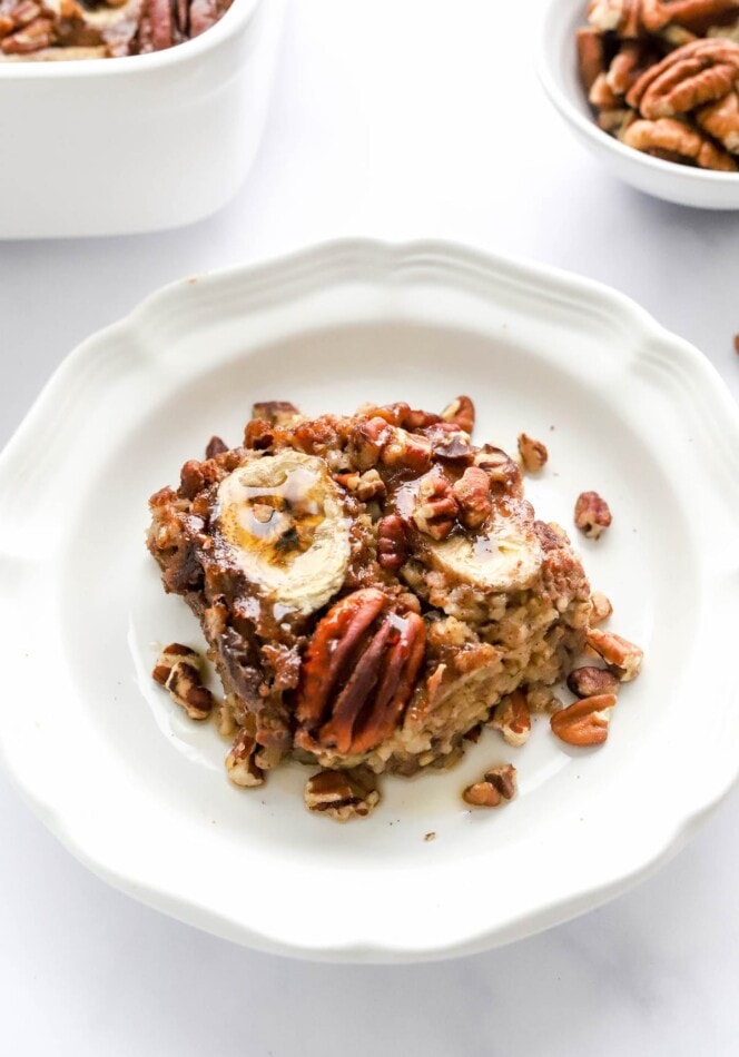 A closeup serving of baked steel cut oatmeal on a plate drizzled with maple syrup.