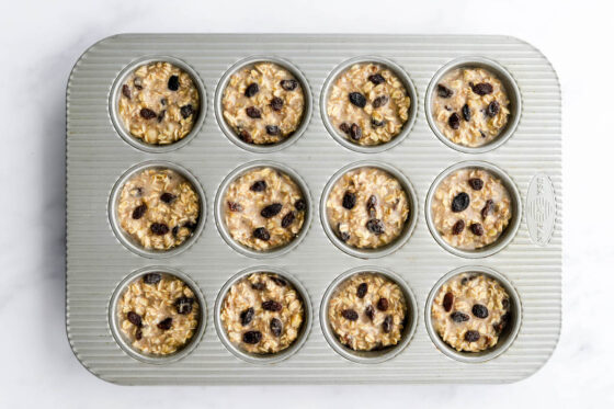 Banana baked oatmeal cup batter in a muffin tin prior to baking.