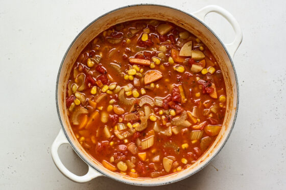 Ingredients for Brunswick stew simmering in a dutch oven.