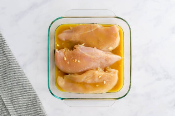 Chicken breasts marinating in dressing.
