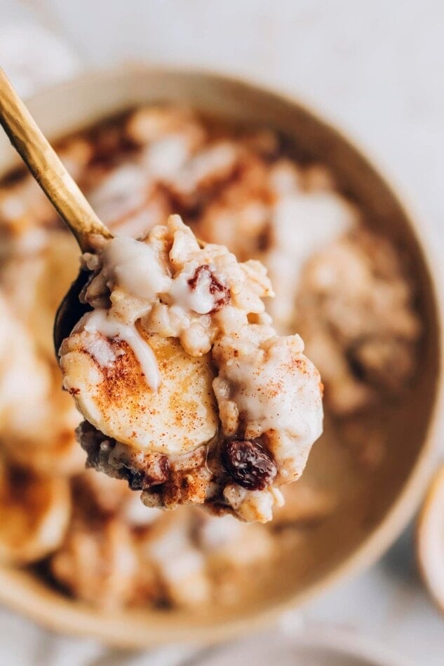 A spoon holding up a bite of cinnamon raisin oatmeal.