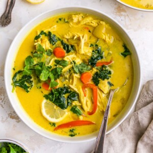 A bowl of detox soup topped with fresh cilantro. A spoon rests in the bowl.