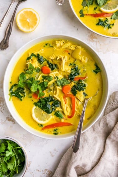 A bowl of detox soup topped with fresh cilantro. A spoon rests in the bowl.