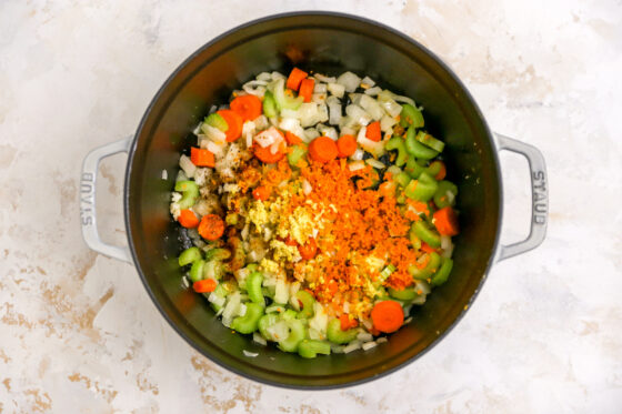 Garlic, ginger, turmeric, cayenne, salt and pepper added to the onions, carrots and celery in a large pot.