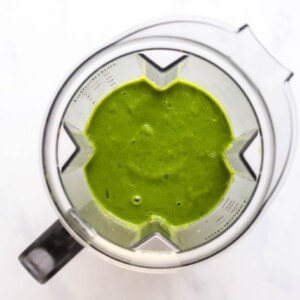 Green detox smoothie ingredients blended in a blender.