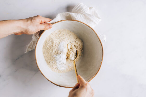 Whole wheat pastry flour, baking powder and salt being mixed together in a bowl.