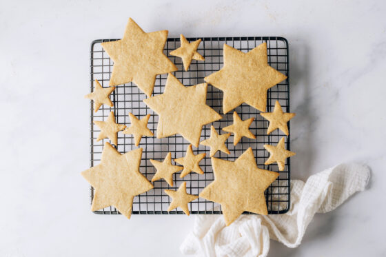 Freshly baked star shaped healthy sugar cookies on a wire cooling rack.