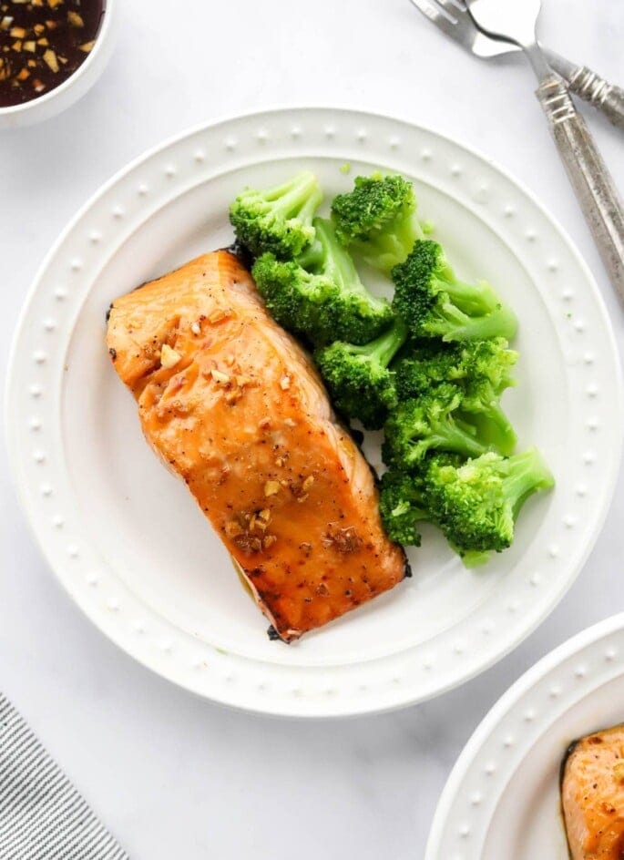 An overhead photo of a plate with a filet of maple glazed salmon. Steamed broccoli is also on the plate.