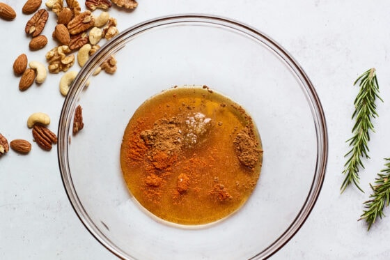 A mixing bowl with maple syrup, salt and cayenne pepper.