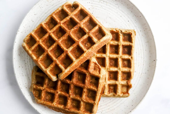 A stack of waffles on a plate.