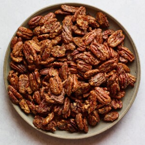 A shallow serving dish containing candied pecans.