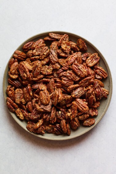 A shallow serving dish containing candied pecans.