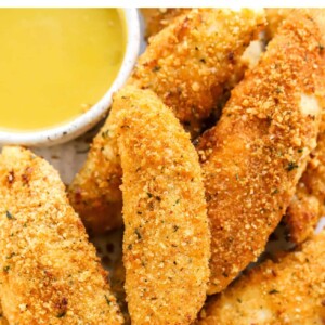 Plate of air fried chicken tenders with honey mustard dip.