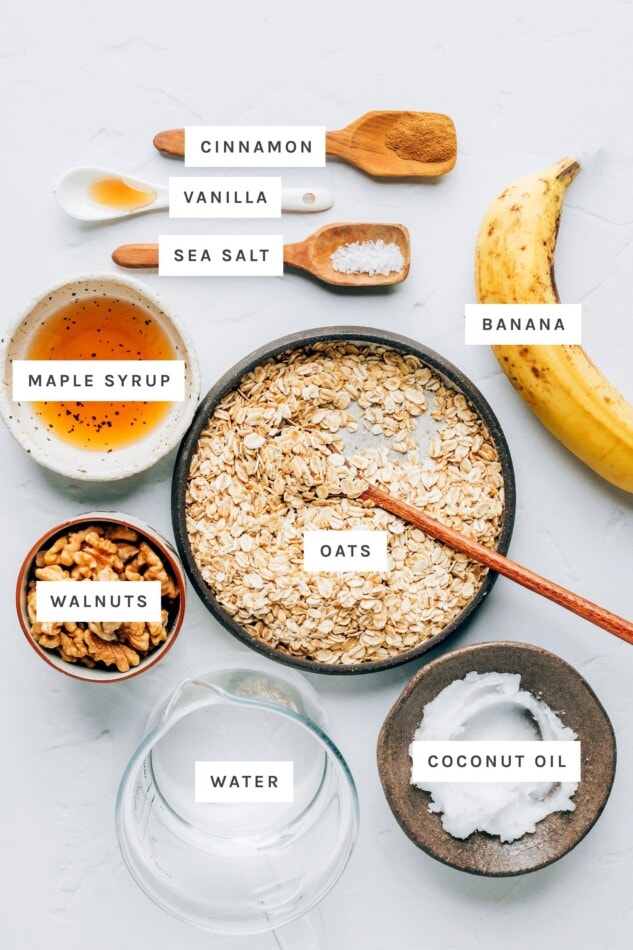 Ingredients measured out to make banana bread oatmeal: maple syrup, vanilla, water, oats, coconut oil, walnuts, banana, sea salt and cinnamon.