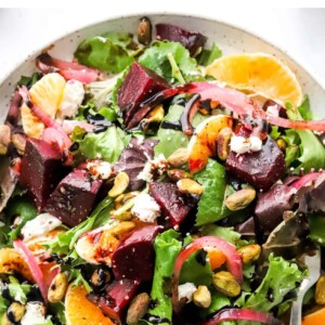 An overhead photo of a plate containing baby beet and clementine salad. A fork rests on the plate.