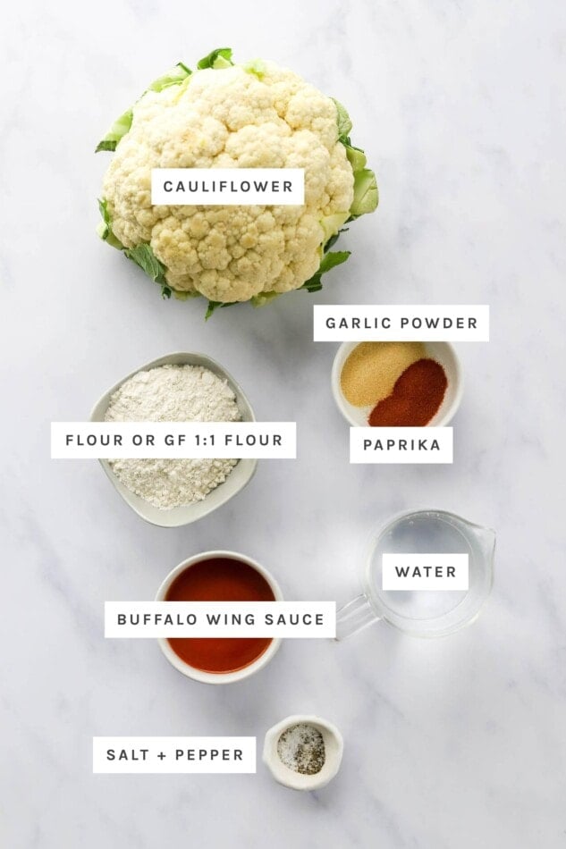 Ingredients measured out to make air fryer buffalo cauliflower: cauliflower, garlic powder, paprika, flour, buffalo sauce, salt and pepper.