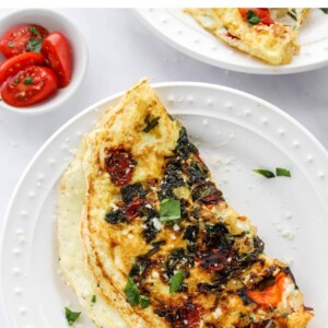 An egg white omelette on a plate, a fork is removing a bite.