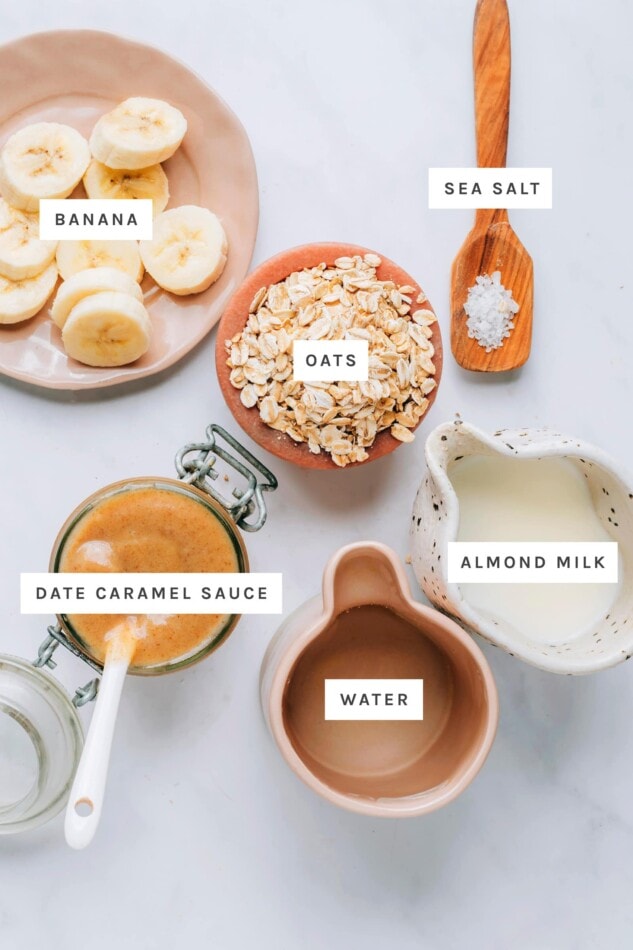 Ingredients measured out to make salted caramel oatmeal: banana, sea salt, oats, date caramel sauce, almond milk and water.