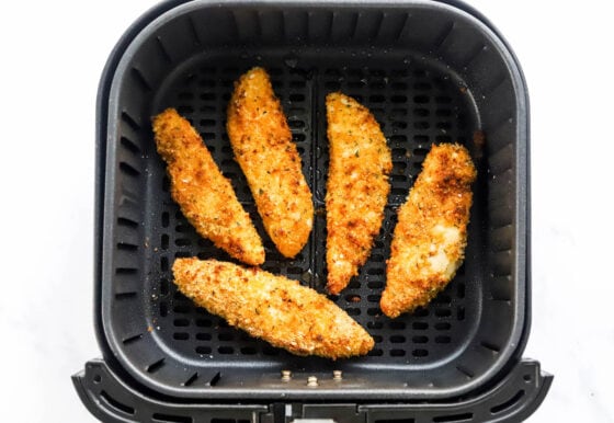 5 air fried chicken tenders in an air fryer basket.