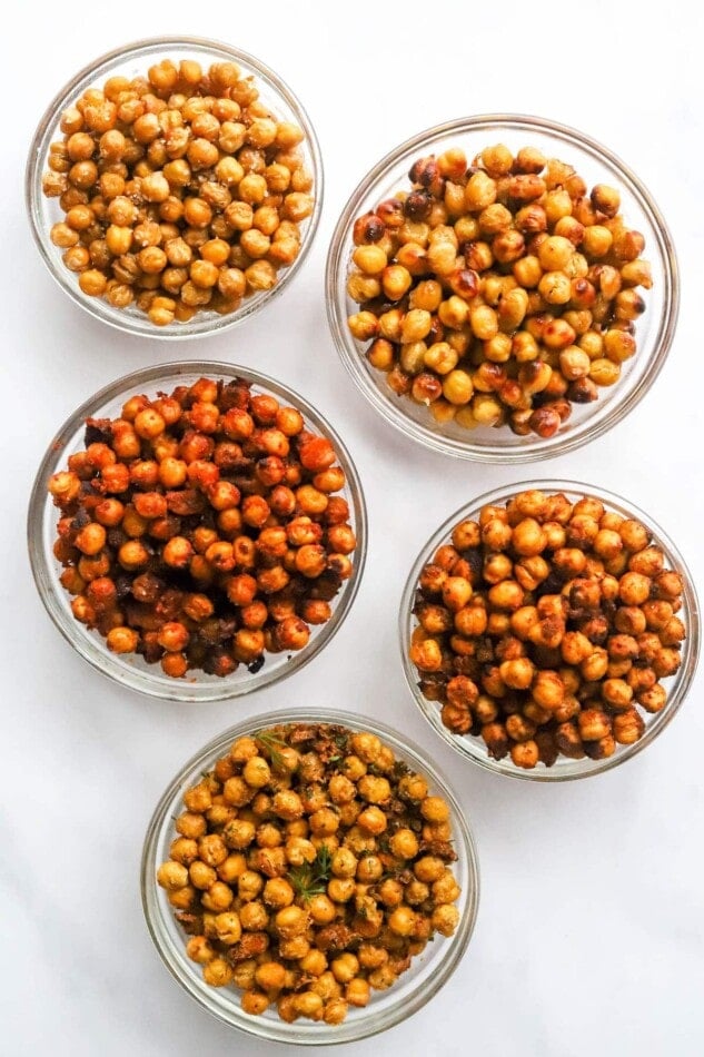 Five glass bowls holding five differently flavored air fried chickpeas.