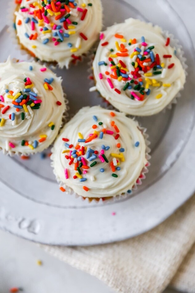 An overhead and closeup view of 4 cupcakes on a plate.