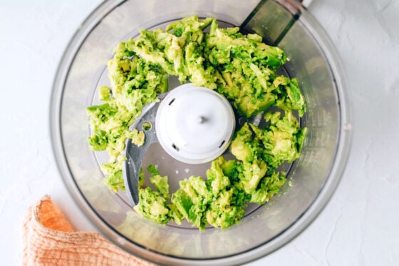Avocado and a pinch of sea salt in a food processor.