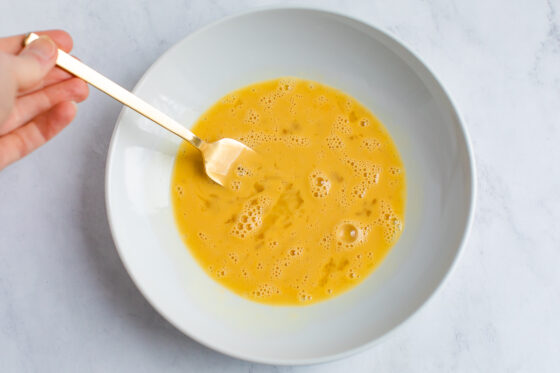 Eggs whisked in a bowl.