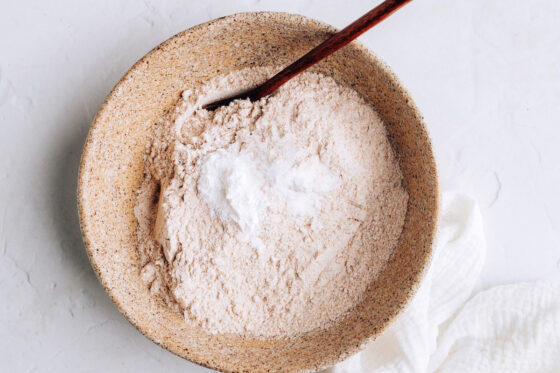 A bowl with flour, baking soda, baking powder and salt.
