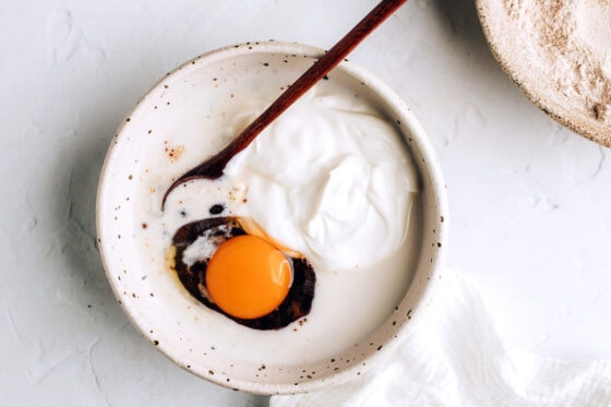 A bowl with coconut sugar, Greek yogurt, almond milk, egg, vanilla and coconut oil.