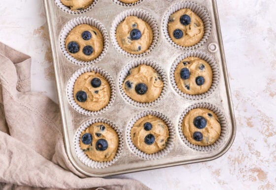 Muffin batter poured into paper lined muffin tin.