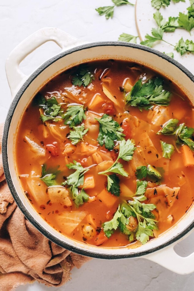 An overhead photo looking at a pot of cabbage soup. It has been topped with fresh cilantro.