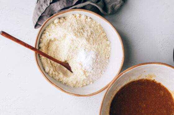A medium mixing bowl containing almond flour, oat flour, baking soda and salt.