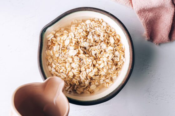 Boiling water added to a bowl of rolled oats.