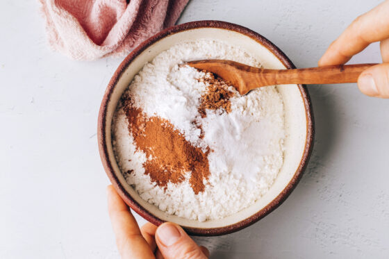 A small bowl containing flour, baking soda, cinnamon, salt and ground nutmeg.