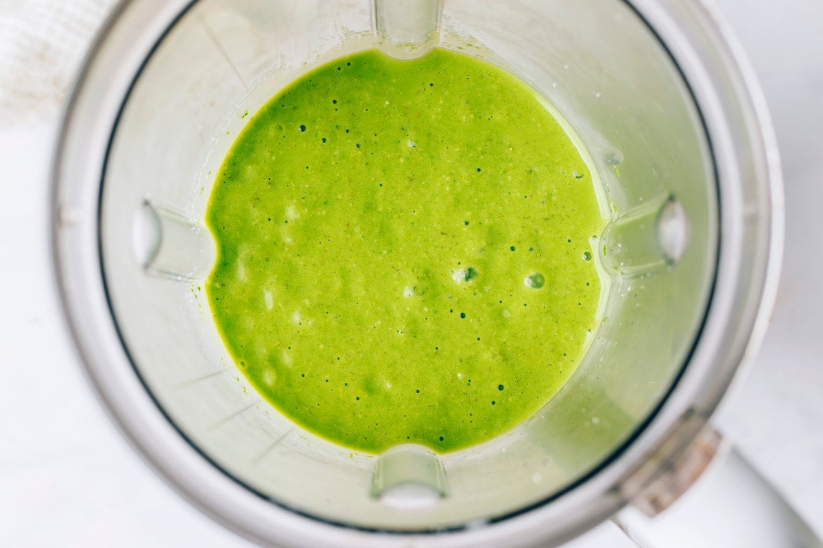 Ingredients for green protein smoothie blended together in a high powered blender.