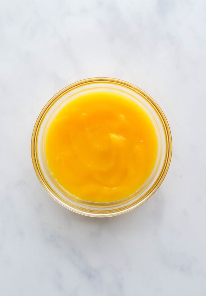 A small glass bowl with mango puree.
