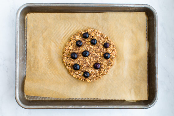 The oatmeal breakfast cookie after baking on a baking sheet lined with parchment paper.