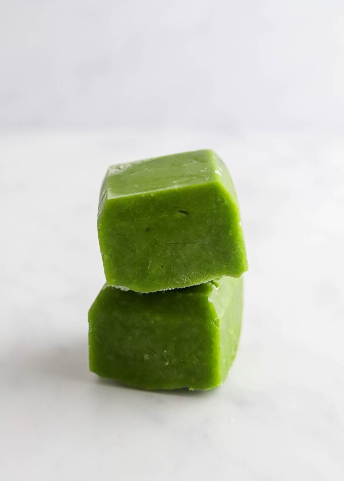 Two cubes of frozen pea puree stacked on top of each other.