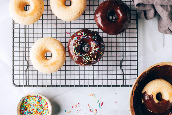 Donuts dipped into chocolate sauce. Some donuts have not been dipped yet.