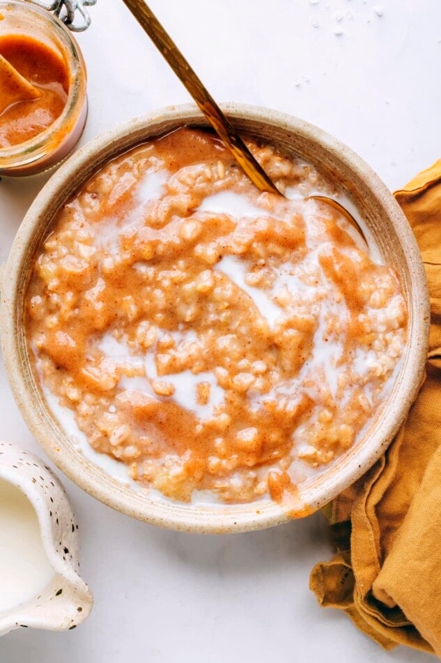 An overhead photo looking at a bowl of salted caramel oatmeal. A spoon rests in the bowl.