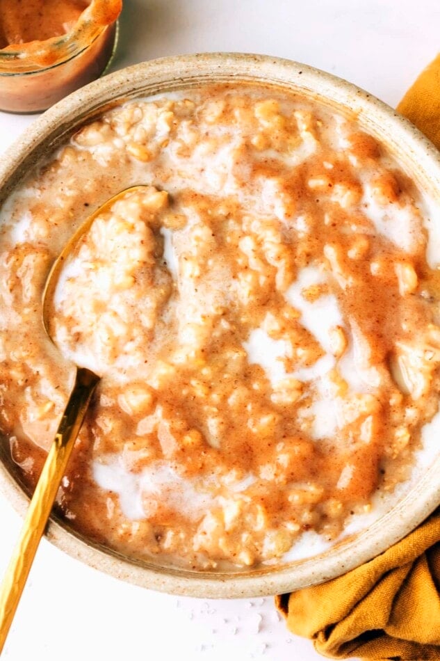 An overhead photo looking at a bowl of salted caramel oatmeal. A spoon rests in the bowl.