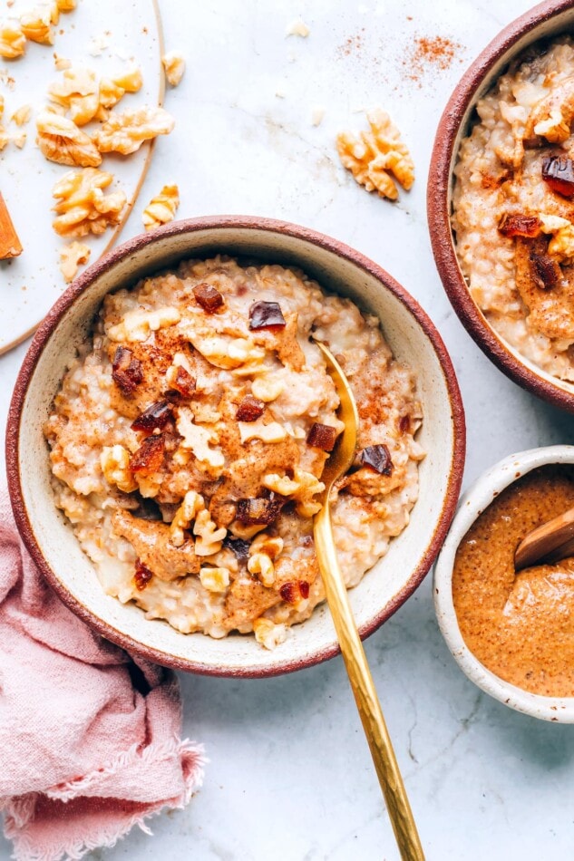 An overhead photo of a bowl containing salted date nut oatmeal. A spoon rests in the bowl.