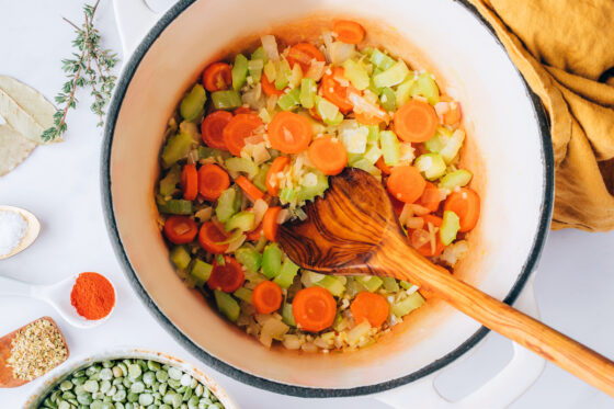 Sautéing onion, celery, carrots and garlic in olive oil in a large pot.