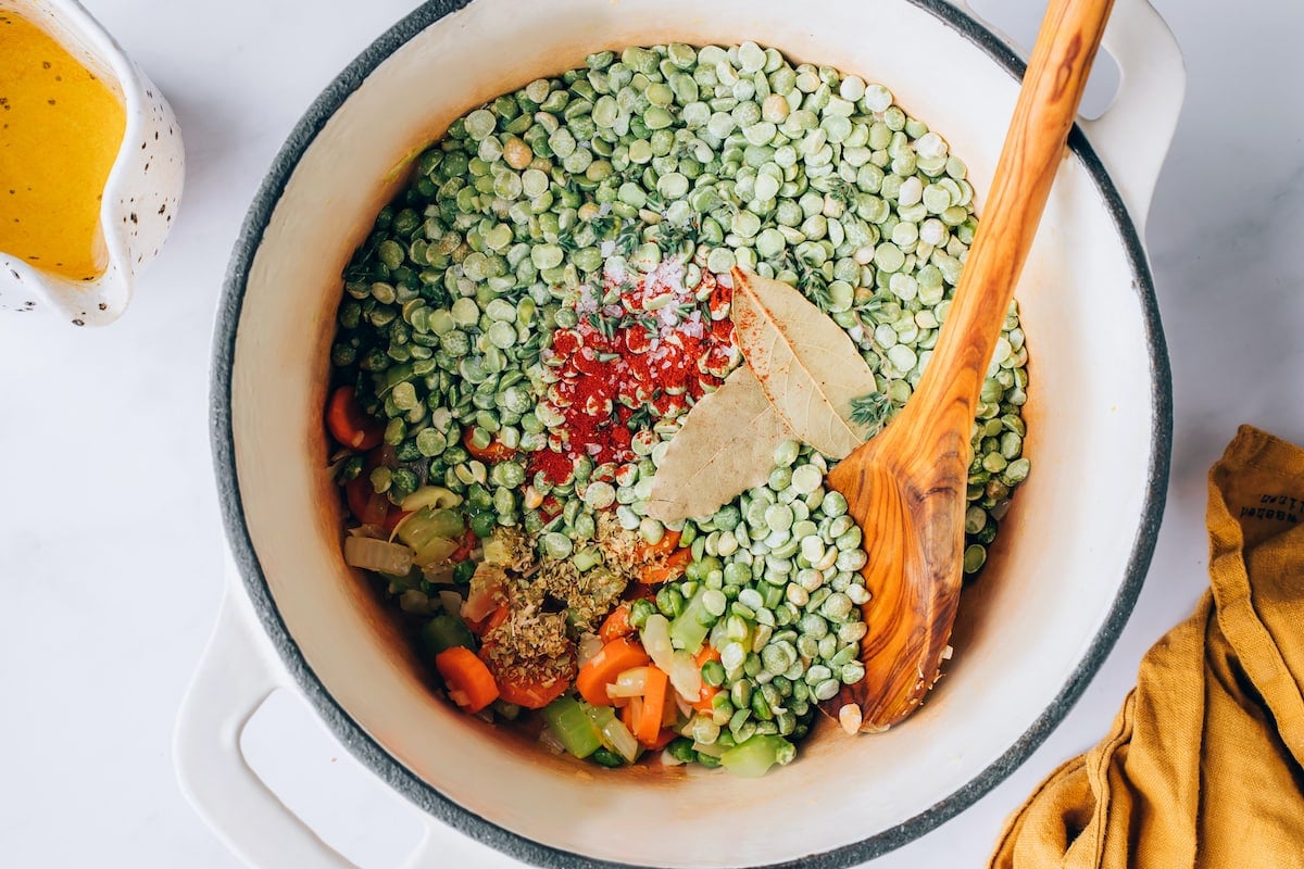 Bay leaves, pepper, salt, thyme, oregano, paprika and split peas added to large pot.